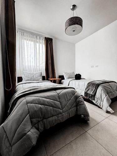a bedroom with two beds and a pendant light at Laguna & Villas Residence in Playa Blanca