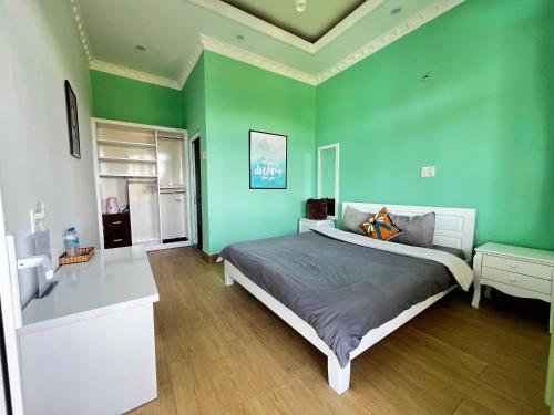 una camera da letto con pareti verdi e un letto grande di Horizon Coffee-Homestay Đà Lạt a Xuan An
