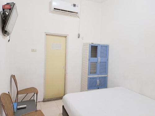 a bedroom with a bed and a blue door at MAWAR Guest House By Hans Management in Bandar Lampung