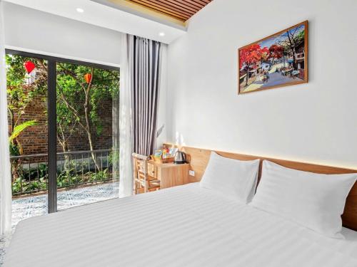 a bedroom with a white bed and a large window at Tam Coc Little Charm Villa & Bungalow in Văn Lâm
