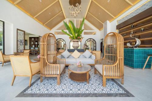 a living room with two chairs and a couch at Howard Johnson by Wyndham Phuket Naiyang in Thalang