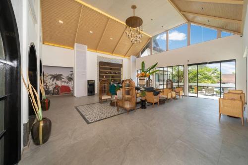 an open living room with a dining room and a living room with windows at Howard Johnson by Wyndham Phuket Naiyang in Thalang