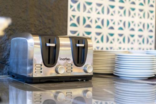 a toaster sitting on top of a table next to plates at Howard Johnson by Wyndham Phuket Naiyang in Thalang