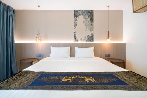 a bedroom with a large white bed with two pillows at Howard Johnson by Wyndham Phuket Naiyang in Thalang