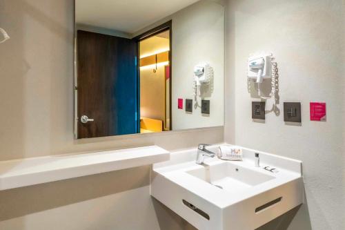 a bathroom with a sink and a mirror at Hotel MX mas cuautitlan Izcalli, Trademark by Wyndham in Cárdenas
