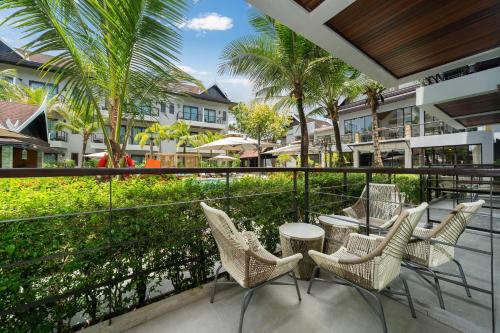 a group of chairs and tables on a balcony at Howard Johnson by Wyndham Phuket Naiyang in Thalang