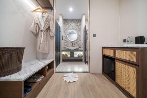 a dressing room with a coat hanging on a wall at Howard Johnson by Wyndham Phuket Naiyang in Thalang