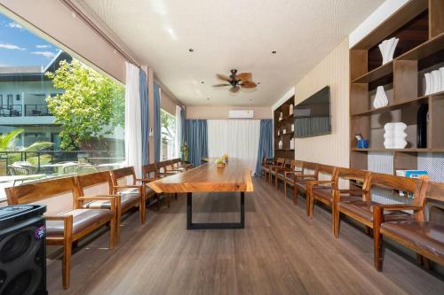 a dining room with a wooden table and chairs at Howard Johnson by Wyndham Phuket Naiyang in Thalang
