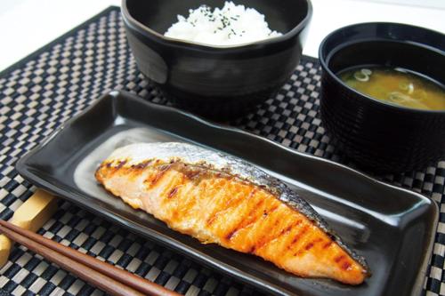 a plate with a piece of fish and a bowl of soup at Hotel Lotus Yokohama in Yokohama