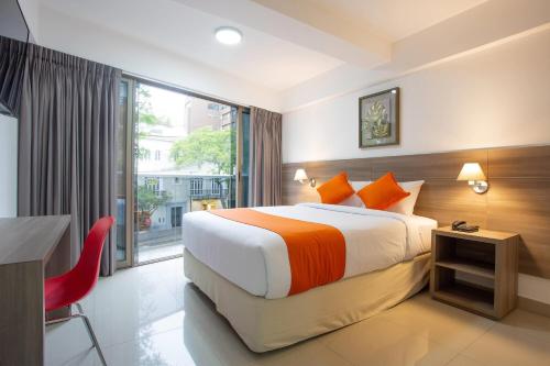 a hotel room with a bed and a desk and a window at Howard Johnson by Wyndham Lima Miraflores Art House in Lima