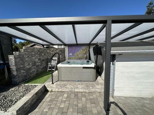 a patio with a hot tub under a roof at Holiday Home Deluxe in Kleinweidelbach