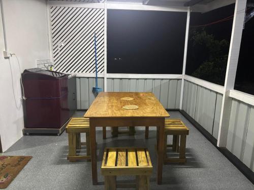 a table and benches on a balcony with a television at Cocos Stay Executive Studio Flat in Labasa