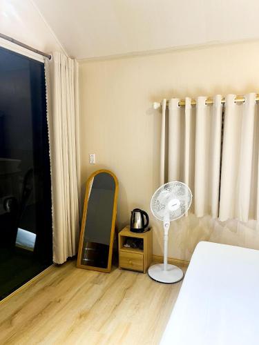 a bedroom with a bed and a mirror and a fan at Dreamy Homestay Tam Đảo in Tam Ðảo