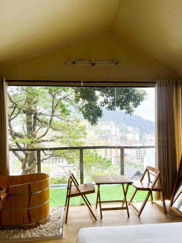 a room with a table and chairs and a large window at Dreamy Homestay Tam Đảo in Tam Ðảo