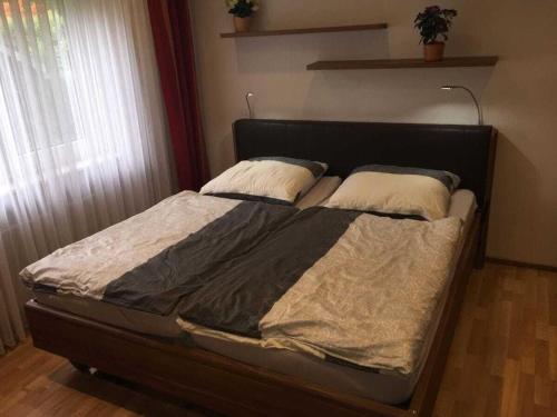 a bed with two pillows on it in a bedroom at One-bedroom apartment in Kleinweidelbach