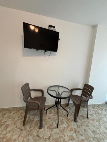 a room with a table and two chairs and a tv at El Gamonal - Paracas in Paracas