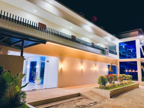 a large house with a balcony at night at De Cairo's Mountain & Ocean View Resort 