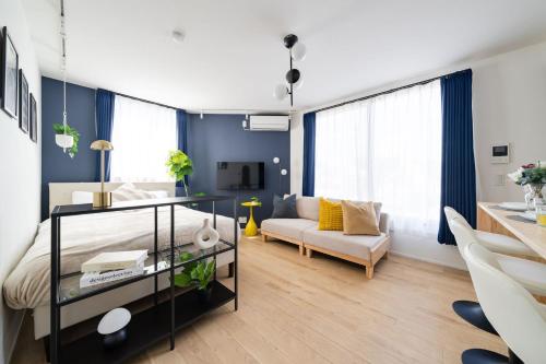 a living room with a bed and a couch at ARiA STAY SHINAGAWA in Tokyo