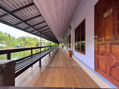 an empty corridor of a building with a wooden door at Aioun At Amphawa in Ban Bang Khan Taek (1)