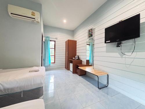 a room with a bed and a tv on a wall at Aioun At Amphawa in Ban Bang Khan Taek (1)