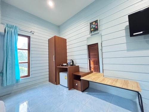 a room with a desk and a tv in it at Aioun At Amphawa in Ban Bang Khan Taek (1)