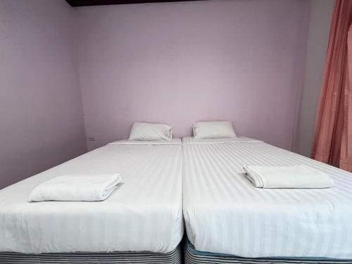 two beds in a room with white sheets and towels at Aioun At Amphawa in Ban Bang Khan Taek (1)