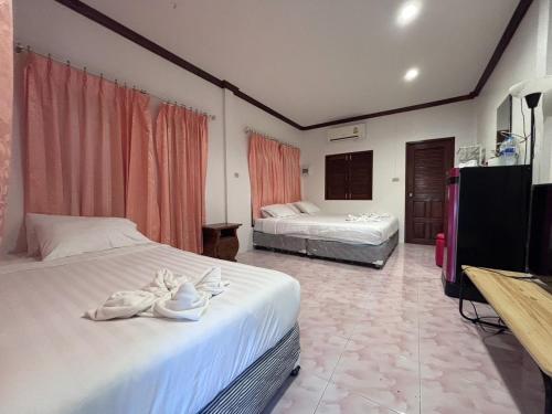 a hotel room with two beds and a flat screen tv at Aioun At Amphawa in Ban Bang Khan Taek (1)