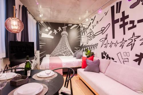 a room with a bed and a table with a couch at ARiA STAY SHINAGAWA in Tokyo