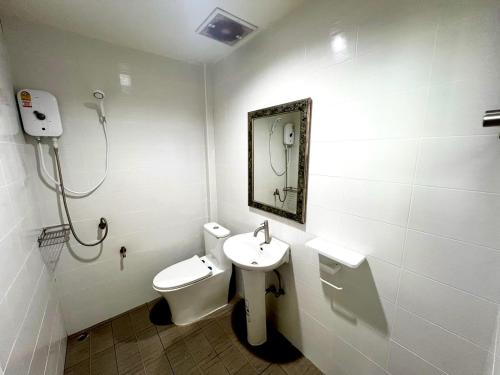 a bathroom with a sink and a toilet and a mirror at Casa Der See Boutique House in Songkhla