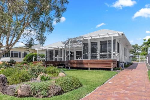 Point VernonにあるEsplanade Ease - Absolute Beachfront in Hervey Bayの広白家屋(ポーチ付)