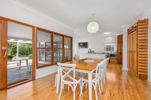 a kitchen and dining room with a wooden table and chairs at Esplanade Ease - Absolute Beachfront in Hervey Bay in Point Vernon