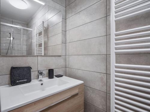 ein Badezimmer mit einem weißen Waschbecken und einem Spiegel in der Unterkunft Appartement 3 pièces pour 6 personnes avec garage aux Saisies - FR-1-809-25 in Les Saisies