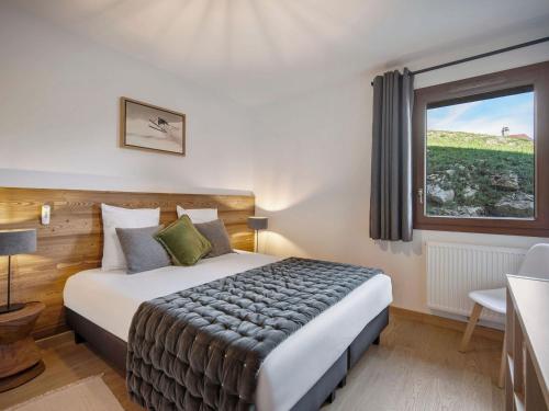 a bedroom with a large bed with a window at Appartement 3 pièces pour 6 personnes avec garage aux Saisies - FR-1-809-25 in Les Saisies