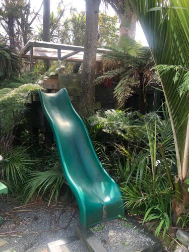 a green slide in the middle of a garden at The Station House Motel in Collingwood