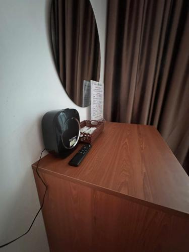 a mirror on top of a wooden dresser with a remote control at Thiên Nhiên Hotel in Ap My Quo