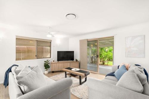 a living room with two couches and a tv at Kiesha House Beachfront Serenity in Point Vernon