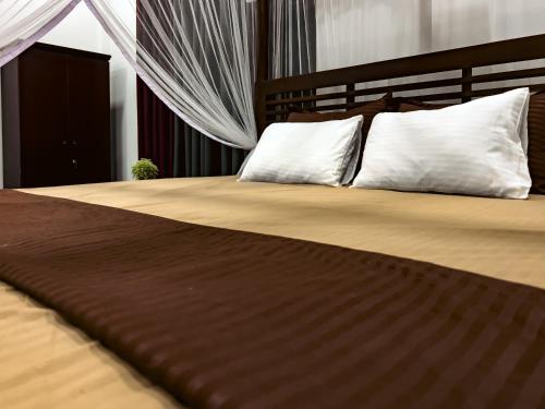 a bedroom with a large bed with white pillows at Finest Retreat Tangalle - Cozy Villa & Pool, Beach Nearby in Tangalle