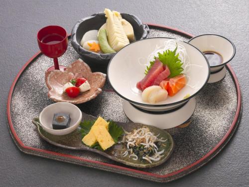 a tray of food with bowls of food on a table at 割烹旅館月茂登 in Kakegawa