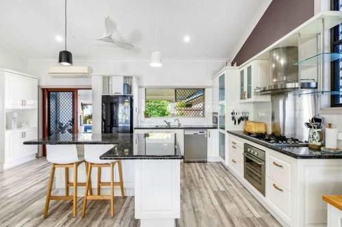 a large kitchen with white cabinets and black counter tops at Sunset Shores Escape in Point Vernon