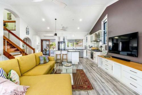 a living room with a yellow couch and a kitchen at Sunset Shores Escape in Point Vernon