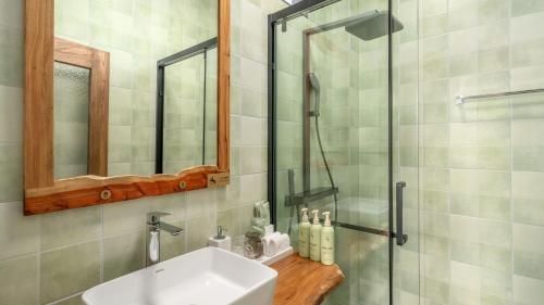 a bathroom with a sink and a shower at Floral Hotel Tengchong Wuwenju B&B in Tengchong