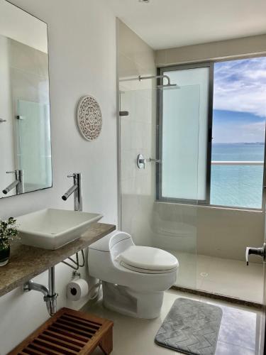 a bathroom with a toilet and a sink and a mirror at Ikigai frente al mar con piscina infinita y Gym in Cartagena de Indias