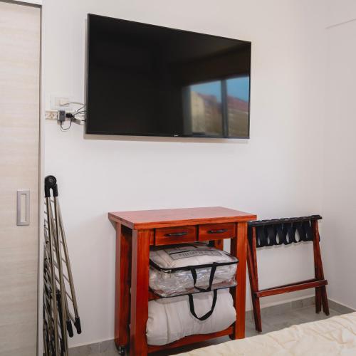 a room with a table with a television on a wall at Asturiano 6 Miramar in Miramar