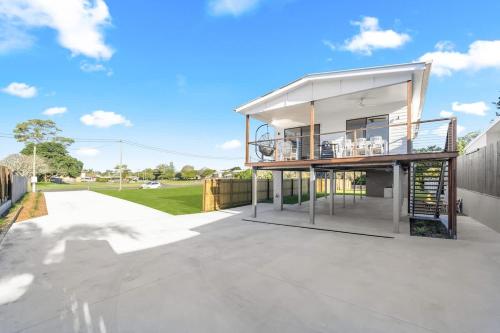 a house with a balcony on top of a patio at Bay Breeze Beachhouse in Scarness