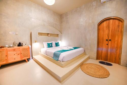 a bedroom with a bed and a wooden cabinet at Ubu Villa Lemme with Rustic Mediterranean Style in Adi Sutjipto