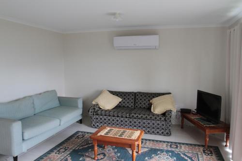 a living room with a couch and a coffee table at Malmsbury Cottage in Malmsbury