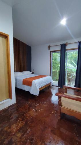 a bedroom with two beds and a large window at Finca San Antonio in Pluma Hidalgo