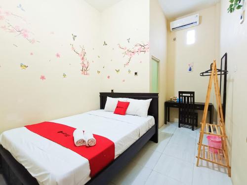 ein Schlafzimmer mit einem Bett mit einer roten Decke in der Unterkunft RedDoorz Syariah near Universitas 17 Agustus Banyuwangi in Banyuwangi