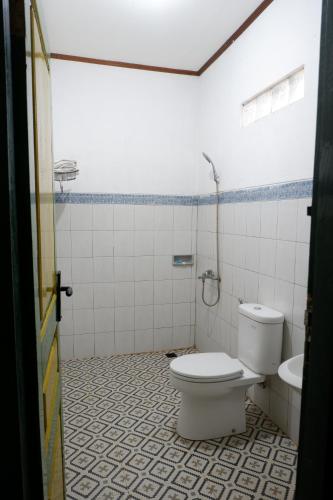 a bathroom with a toilet and a sink at Omah Kebon Guest House in Temanggung