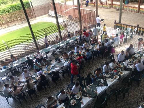 a large group of people sitting at tables eating food at Club Campestre El Rubí in Carmen de Apicalá